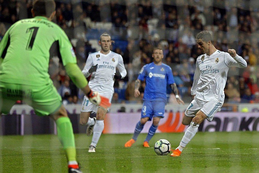 Real Madrid’s Cristiano Ronaldo (right), attempts a shot against Getafe’s goalkeeper Emiliano Martinez during encounter against Getafe at the Santiago Bernabeu on Saturday. - AP photo