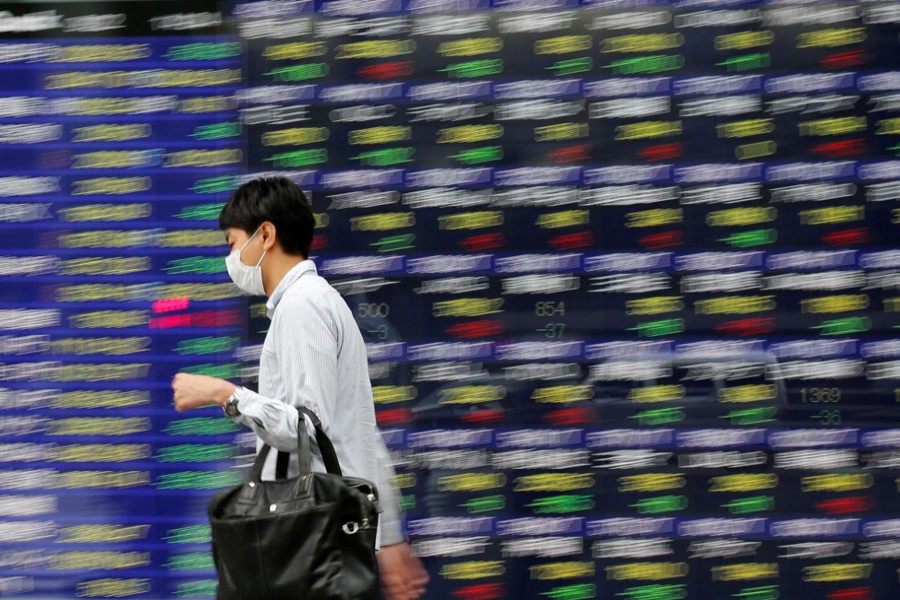 A man walks past an electronic stock quotation board outside a brokerage in Tokyo, Japan, September 22, 2017. Reuters/File Photo