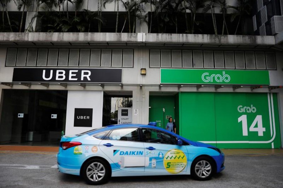 A ComfortDelgro taxi passes Uber and Grab offices in Singapore - Reuters photo