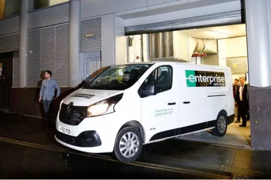 A van and a group of people leave the building which houses the offices of Cambridge Analytica.  - Reuters