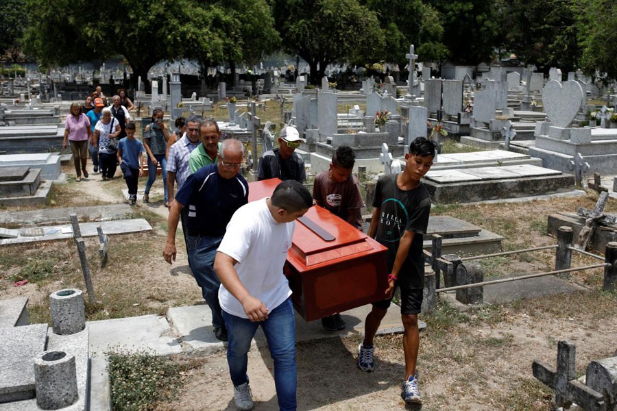 Mourners carry the coffin of Javier Rivas, one of the inmates who died during a riot and fire in the cells of the General Command of the Carabobo Police, during his funeral in Valencia, Venezuela March 29, 2018. Reuters.