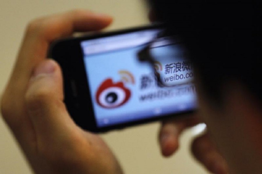 A man holds an iPhone as he visits Sina's Weibo microblogging site in Shanghai May 29, 2012. Reuters/Files