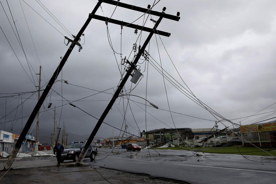 A police officer walks next to damaged electrical installations in Guayama, Puerto Rico. Reuters.