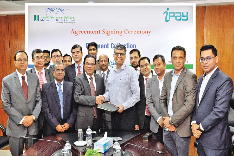 Kazi Masihur Rahman, Managing Director and CEO of Mercantile Bank Limited, and ATM Zakaria Swapan, founder & CEO of iPay Systems Limited, exchanging documents after signing an agreement in the capital recently in presence of senior executives of the two companies