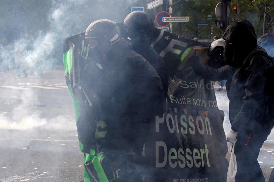 Tear gas floats around masked protesters during clashes with French CRS riot police at the May Day labour union rally in Paris, France on Tuesday - Reuters photo