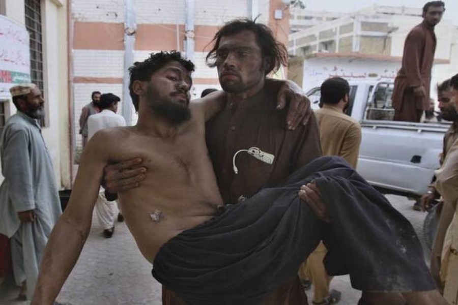 A mine worker carries an injured colleague upon arrival at a hospital in Quetta, Pakistan, on May 5, 2018. According to the Pakistan Central Mines Labour Federation (PCMLF), about 100 to 200 labourers die on average in coal mine accidents every year in the country.    Photo credit: AP