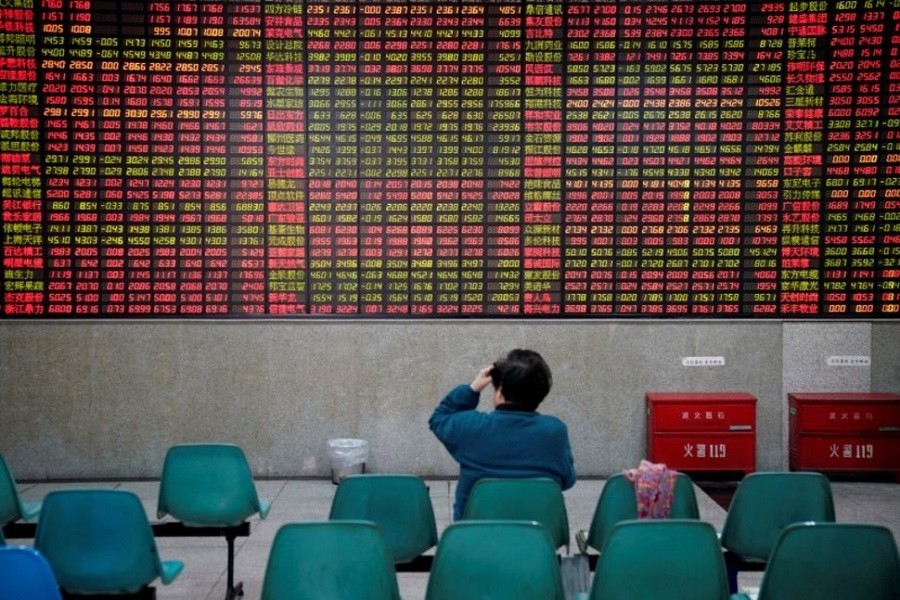 An investor looks at an electronic board showing stock information at a brokerage house in Shanghai, China November 24, 2017. Reuters/Files