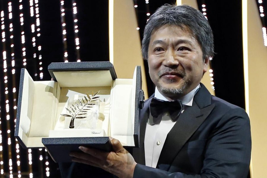 Director Hirokazu Kore-eda poses with the Palme d'Or award for his film "Shoplifters". Reuters File Photo