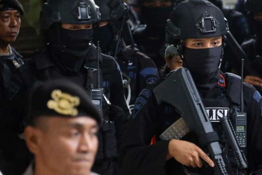 Members of Indonesian police counter terrorism unit Special Detachment 88 escort radical cleric Aman Abdurrahman upon arrival for his trial at a district court in Jakarta, Indonesia, Friday, May 25, 2018. - AP