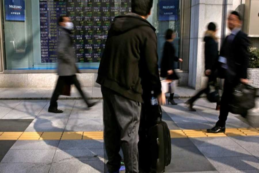 A man looks at an electronic stock quotation board outside a brokerage in Tokyo, Japan, February 9, 2018. Reuters/File Photo