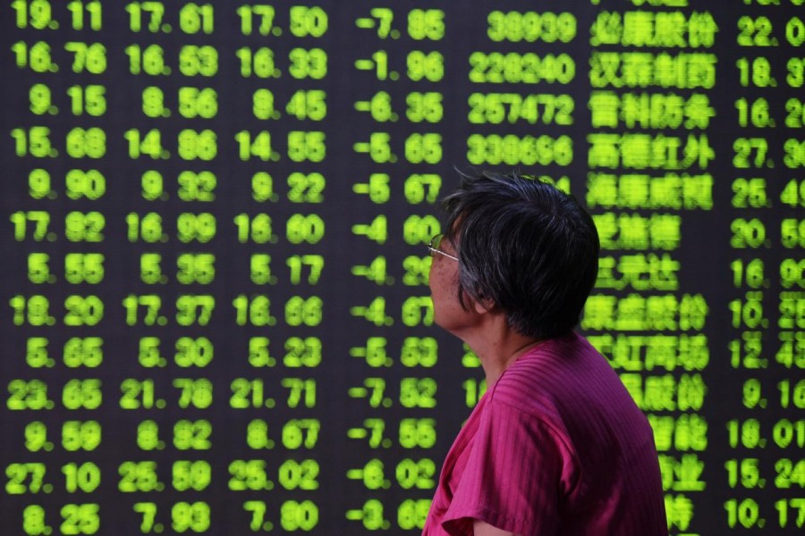 A woman looks at an electronic board showing stock information at a brokerage house in Hangzhou, Zhejiang province, China May 30, 2018. Reuters/Files