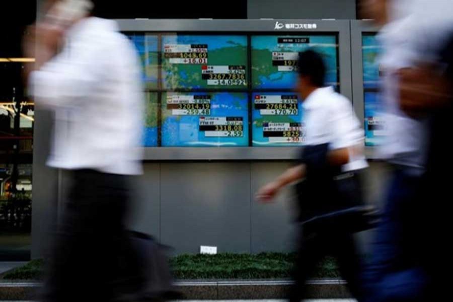 People walk past an electronic board showing exchange rate between Japanese Yen and US Dollar outside a brokerage at a business district in Tokyo, Japan, August 9, 2017. Reuters/Files