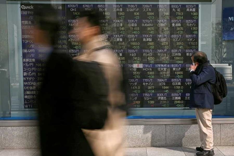 A man looks at an electronic stock quotation board outside a brokerage in Tokyo, Japan, February 9, 2018. Reuters/Files