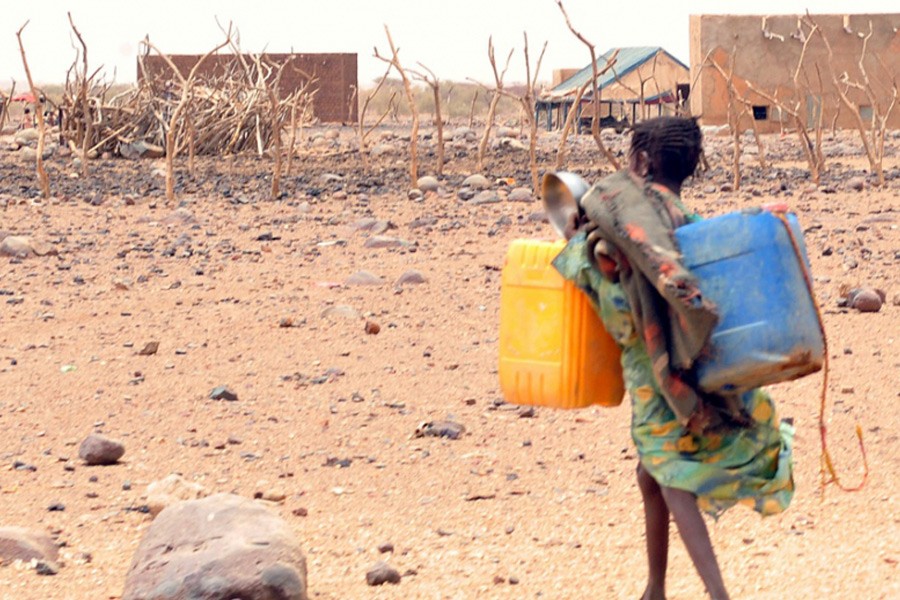 A girl carries cans to fill with water in southeastern Mauritania, on May 4, 2012. The food crisis across West Africa’s Sahel region puts millions at risk of hunger, according to the UN. Photo Credit: Abdelhak Senna.