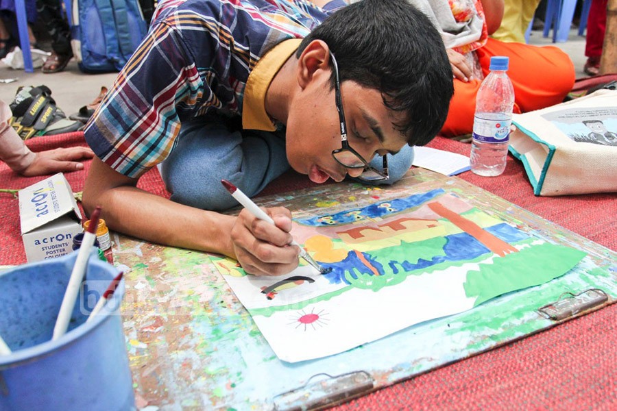 An autistic child is drawing his version of rural Bangladesh on the occasion of World Autism Awareness Day. Photo: bdnews24.com