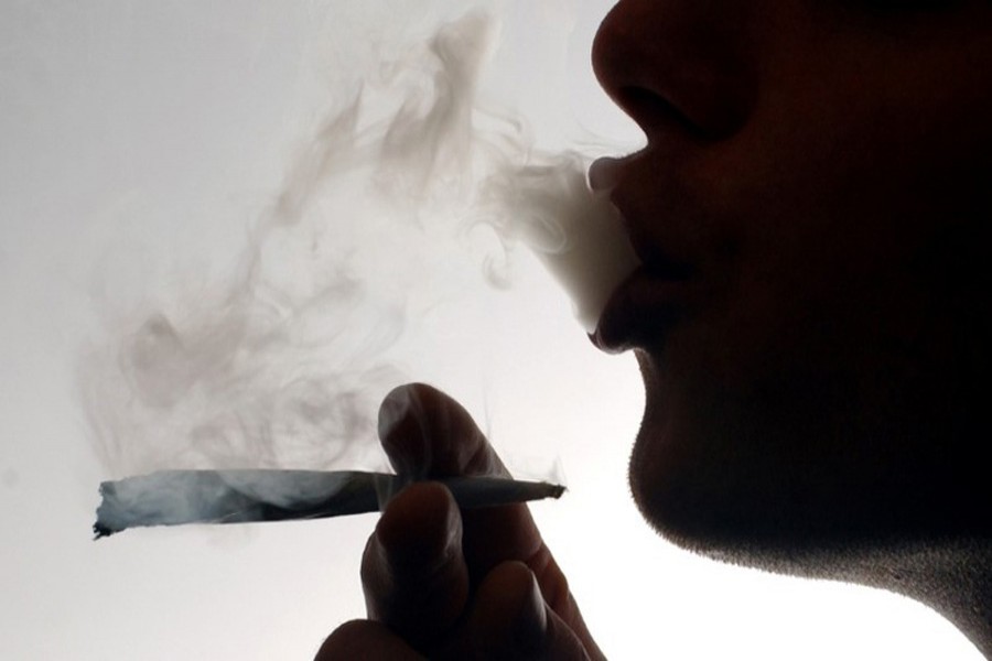 An unidentified man smokes a cannabis cigarette at a house in London, Britain, January 24, 2004. Reuters/File Photo