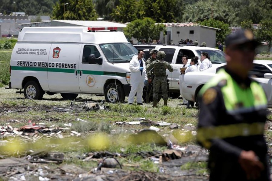 Forensic technicians chat with soldiers near a site damaged due to fireworks explosions in the municipality of Tultepec, on the outskirts of Mexico City, Mexico on Thursday - Reuters photo