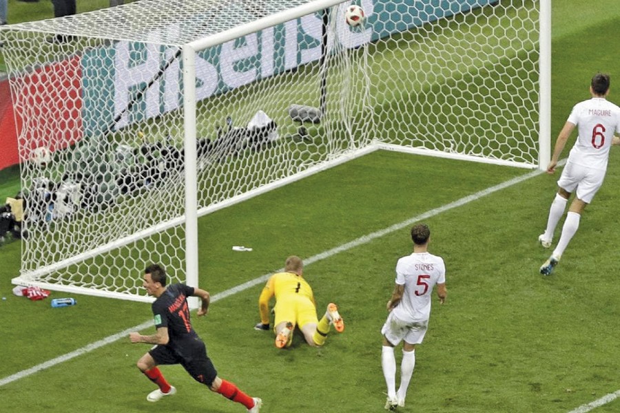 Croatian striker Mario Mandzukic (left) celebrates after scoring the winning goal in 109th minute in his team's 2-1 World Cup semi-final victory over England. 	— AP