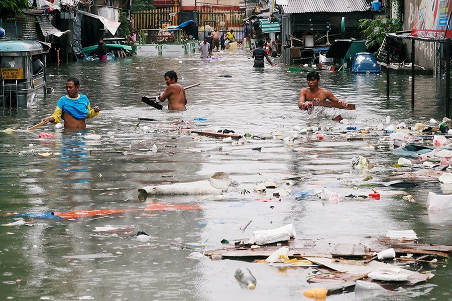 Residents gather plastics and other recyclable materials along a flooded street caused by monsoon rains and Tropical Storm Son-Tinh in Quezon city, Metro Manila, in Philippines on Tuesday last - Reuters photo used for representational purpose