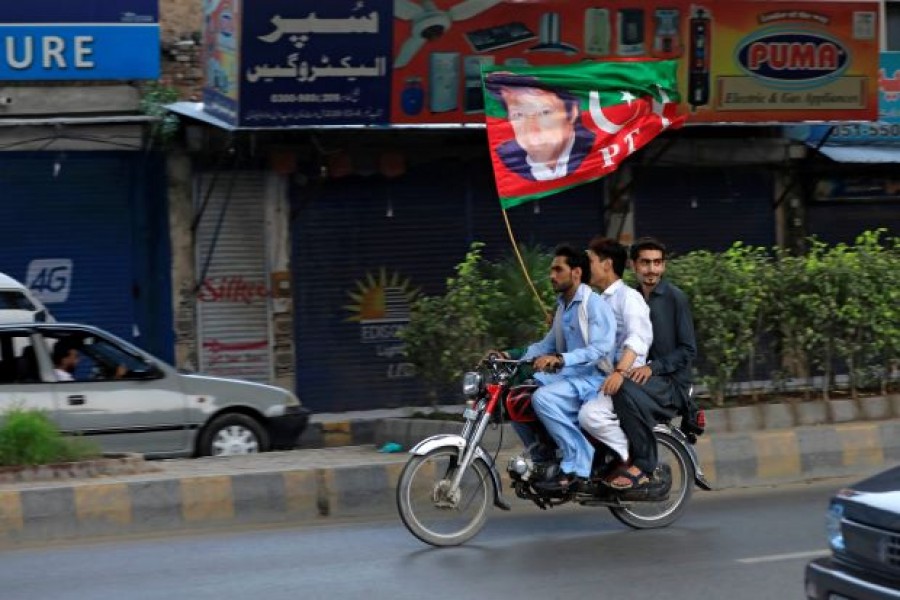 Supporters of Imran Khan, chairman of the Pakistan Tehreek-e-Insaf (PTI), political party wave a party flag as they celebrate during the general election in Rawalpindi, Pakistan July 25, 2018. Reuters