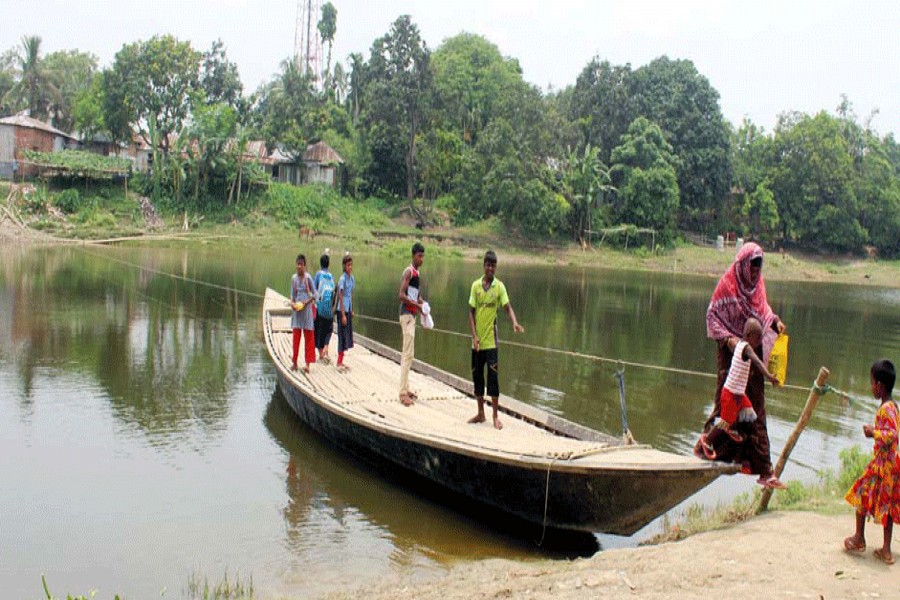 Villagers crossing the Nandakuja river by a boat at Mollabazar Terminal under Gurudaspur upazila in Rajshahi on Sunday pulling a rope in absence of a boatman  	— FE photo