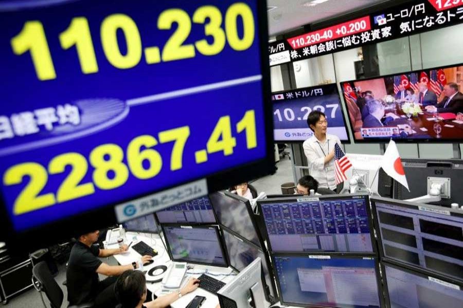 Employees of a foreign exchange trading company work near monitors broadcasting TV news reporting from the summit between the US and North Korea (R) and the Japanese yen's exchange rate against the US dollar and Nikkei share average in Tokyo, Japan, June 12, 2018. Reuters/File Photo