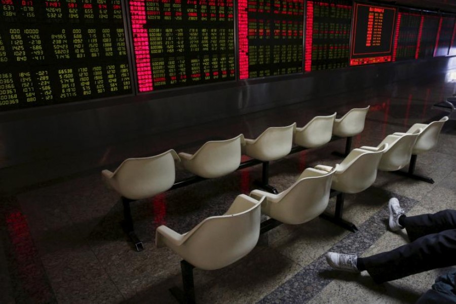 A man's legs are pictured as he looks at an electronic board showing stock information at a brokerage house in Beijing, China, January 5, 2016. Reuters/Files