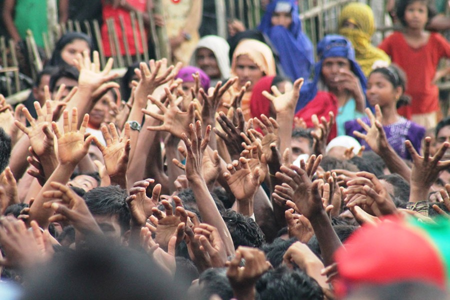 Rohingya refugees try to grab relief supplies on the street in front of the Kutupalong refugee camp in Ukhia, Cox's Bazar, Bangladesh on September 12, 2017. Courtesy: Jesmin Papri/BenarNews