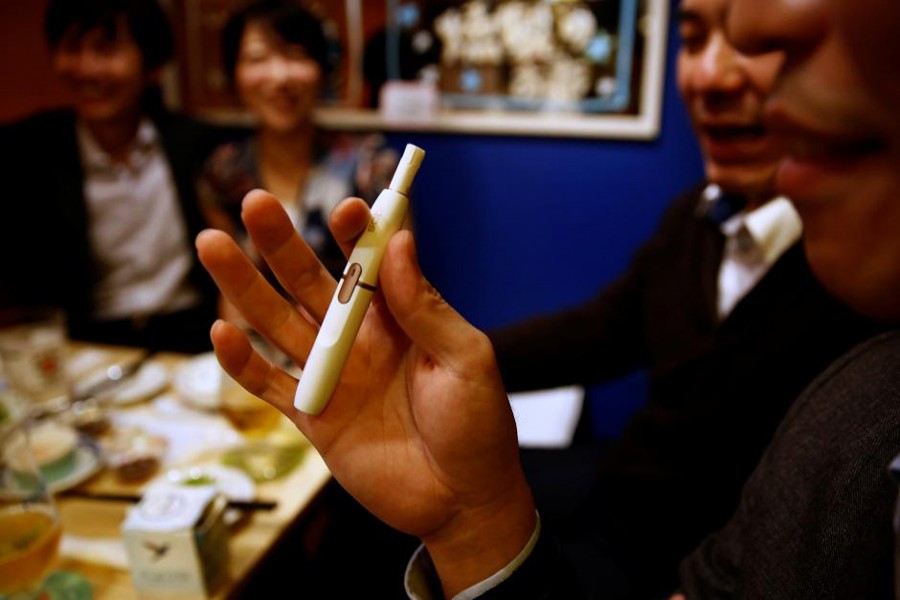 A man smokes iQOS e-cigarette at a restaurant in Tokyo, Japan November 2, 2017. Reuters/File photo