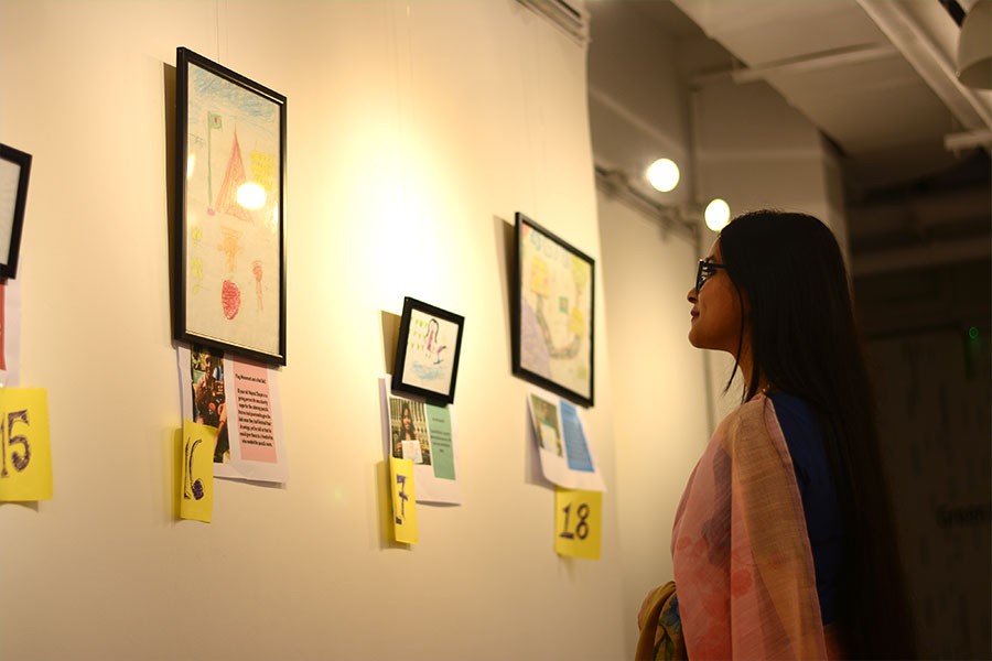 A visitor at the art exhibition named, "Shoishob", showcasing various artworks created by street children