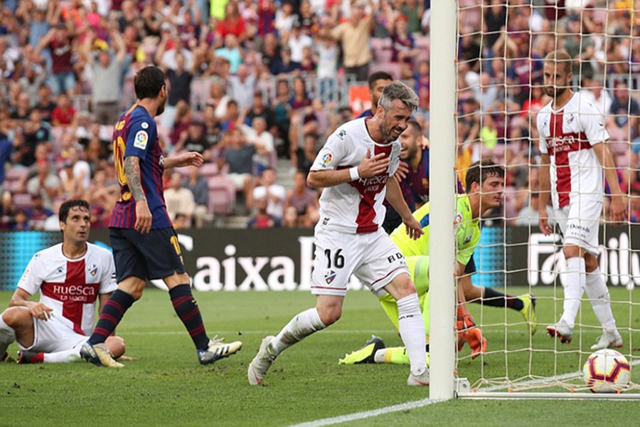 The Huesca defender (centre) could do nothing but watch on as he accidentally put the ball through his own net — Reuters photo