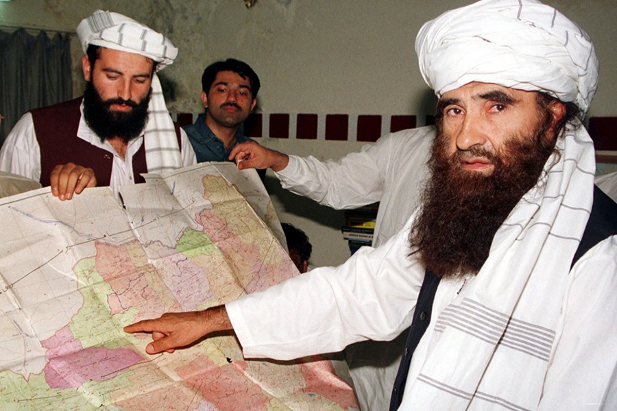 Jalaluddin Haqqani (R), the Taliban's Minister for Tribal Affairs, points to a map of Afghanistan during a visit to Islamabad, Pakistan on October 19, 2001 while his son Naziruddin (L) looks on — Reuters/File