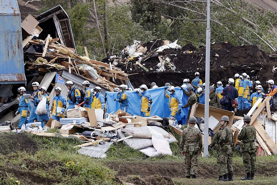 Police officers and members of the Japan Self-Defense Forces (JSDF) working in area damaged by a landslide caused by an earthquake in Atsuma town, Hokkaido, northern Japan, in this photo taken on Saturday — Kyodo photo REUTERS