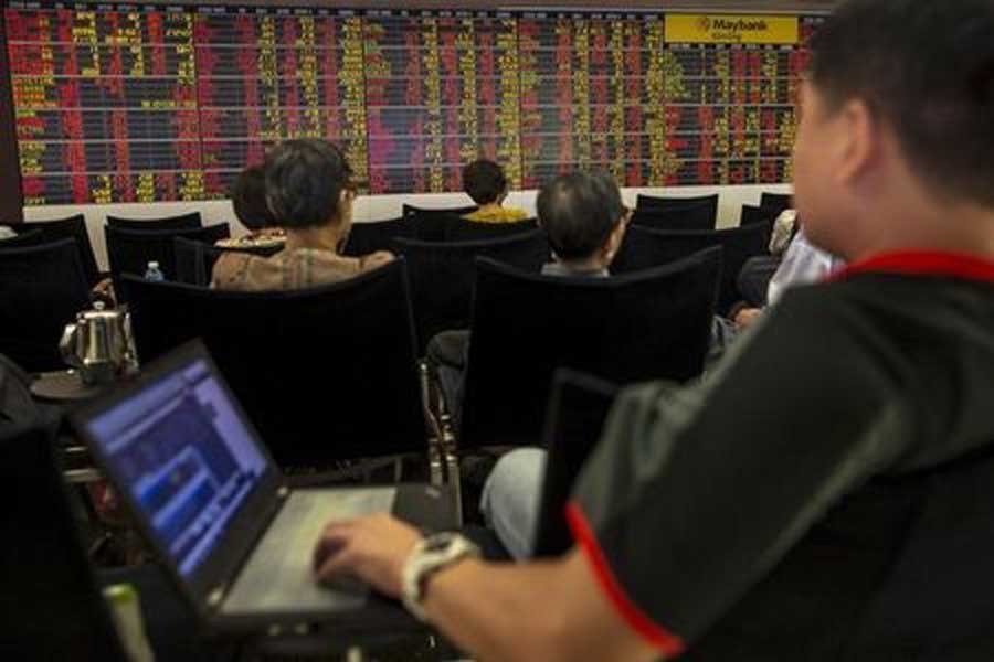 Thai investors sit in front of an electronic board displaying live market data at a stock broker's office in central Bangkok, Thailand, August 24, 2015. Reuters/Files