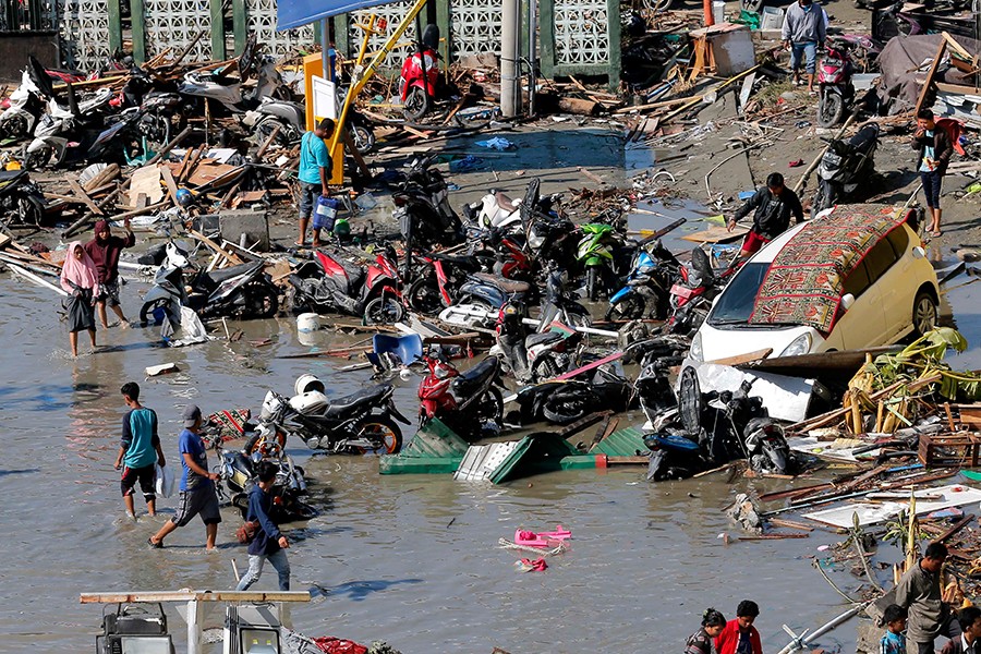 People survey damage outside the shopping mall following earthquakes and tsunami in Palu, Central Sulawesi, Indonesia on Sunday — AP photo