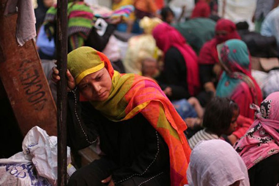 Rohingya women gather in a temporary shelter after a fire razed their camp in the Kalindi Kunj area of New Delhi, April 15, 2018 – AP