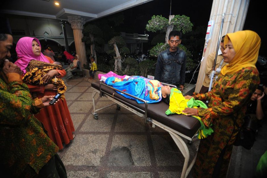 A relative pushes a patient on a bed shortly after an earthquake hit, at Larasati hospital in Pamekasan, Indonesia on Thursday — Reuters photo