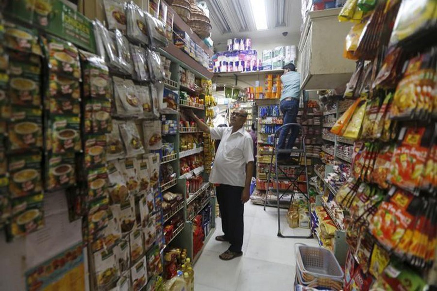 Employees work inside a grocery store at a residential area in Mumbai, March 14, 2016. Reuters/Files