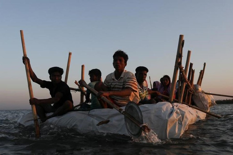 Rohingya refugees sail on an improvised raft across the Naf River to reach Bangladesh on November 29, 2017 — Reuters/File