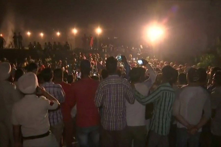 People gather at the train accident site in Amritsar, India October 19, 2018 in this still image from video provided by Reuters TV. ANI News via Reuters