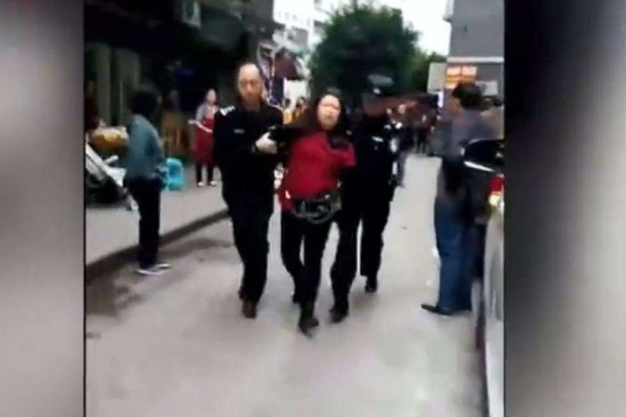 Police restrained the attacker - a 39-year-old woman wearing a red jumper, only identified by her surname Liu. Photo derived from Weibo