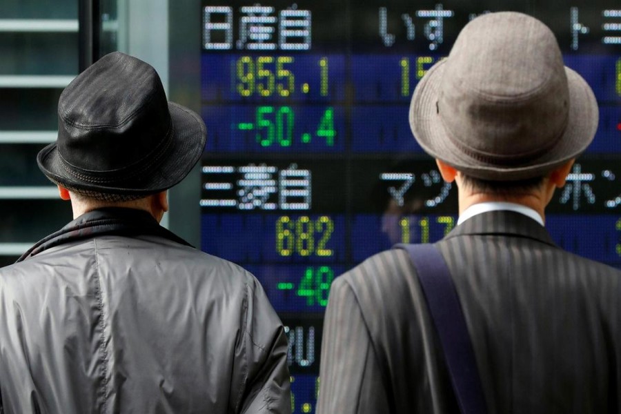 Men look at a stock quotation board showing share prices of Nissan Motor Co (top) and Mitsubishi Motors outside a brokerage in Tokyo, Japan, November 20, 2018. Reuters