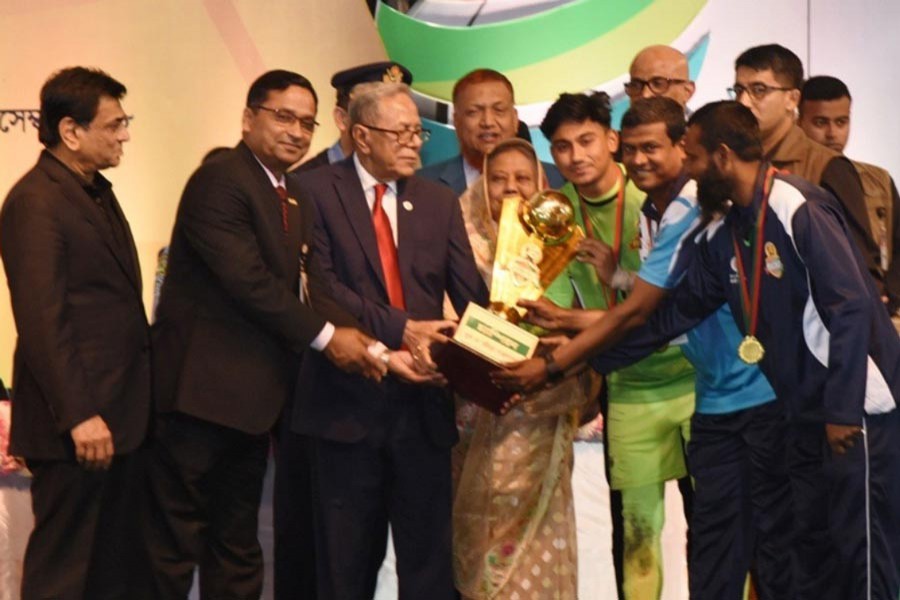 President Abdul Hamid handing over trophies of the Bangabandhu Sheikh Mujibur Rahman National Under-17 Gold Cup Football Tournament as the chief guest at the Bangabandhu National Stadium in the city on Sunday	— UNB