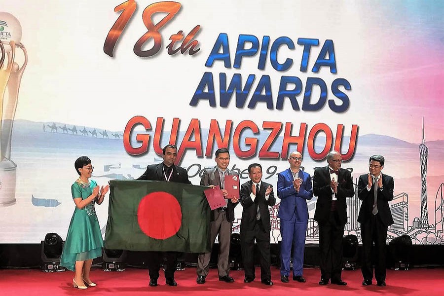 Representative from Bangladesh showcases the flag of the country after receiving awards for a2i’s Public Service and Digital Health Innovations at the 18th prestigious Asia Pacific ICT Alliance APICTA Award 2018 held at Guangzhou in China on October 13. Photo: UNDP