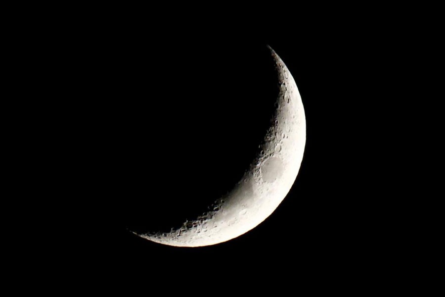 FILE PHOTO: The waxing crescent moon is seen over a city center of Warsaw April 22, 2015 - REUTERS/Kacper Pempel