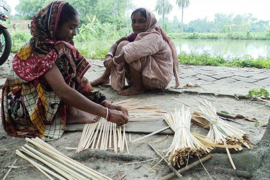 A craftswoman preparing winnowing fan at Paulpara under Dupchanchia upazila of Bogura district 	— FE Photo