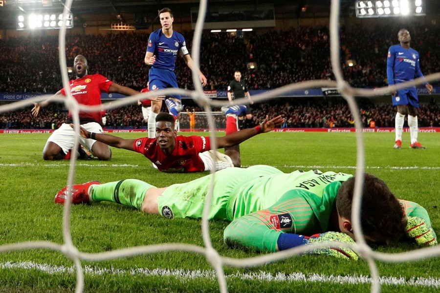 Midfielder Paul Pogba celebrates scoring Manchester United’s second goal as Chelsea keeper Kepa Arrizabalaga cuts a dejected figure lying on the turf — Reuters action image