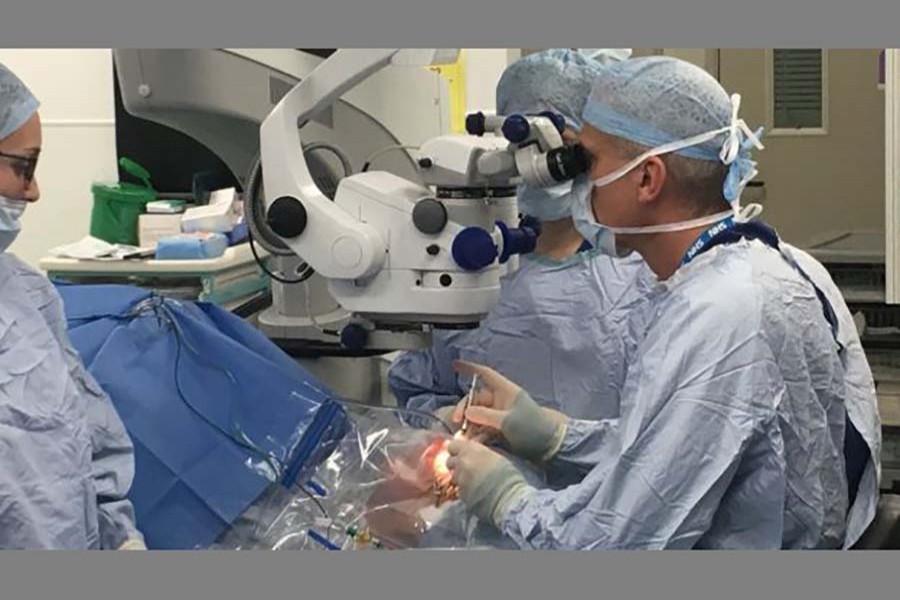 Prof Robert MacLaren inserting gene therapy into Janet Osborne's left eye. Photo: Fergus Walsh