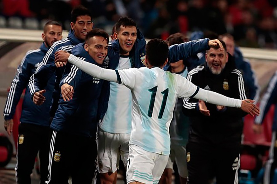 Angel Correa celebrates his winning goal with Argentina's substitutes and coaches — AP photo