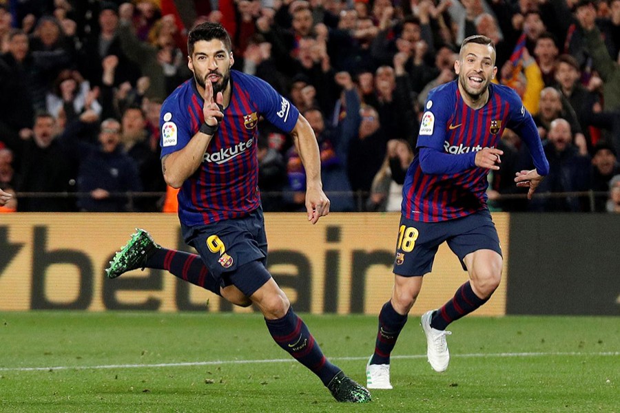 Barcelona's Luis Suarez celebrates with Jordi Alba after scoring a late screamer against Atletico Madrid at the Nou Camp on Saturday — Reuters photo